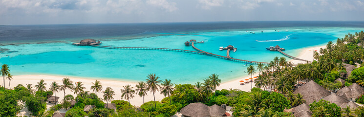 Panoramic Maldives paradise island. Tropical aerial landscape, seascape jetty pier water villas....