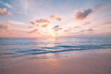 Rolgordijnen Beautiful sunset horizon sea or ocean. Vibrant soft colors magic sunlight. Small clouds yellow golden sky, reflection of sun water sand on beach. Peaceful romantic vacation in tropical island paradise © icemanphotos