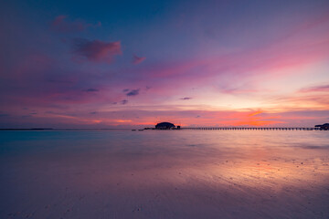 Amazing sunset panorama at Maldives. Luxury resort villas seascape with soft led lights under...