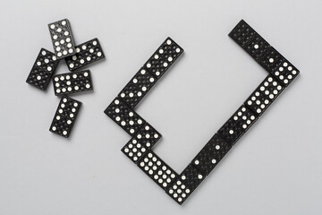 Black domino tiles on color background, top view