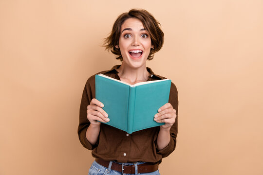Photo of impressed funky lady wear brown shirt enjoying good book open mouth isolated beige color background