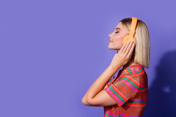 Side profile photo relaxed lady closed eyes touch headphones in front of empty space audio records app isolated on purple color background