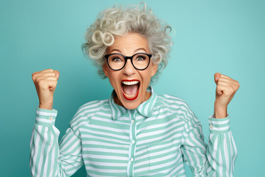 Elderly exultant overjoyed jubilant woman 50s years old wear light striped shirt look camera spread hands say wow isolated on plain pastel blue cyan color background studio portrait Lifestyle concept