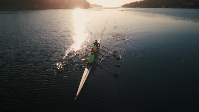 Cinematic drone shot of a sports rowing boat with a crew of young sportsmen