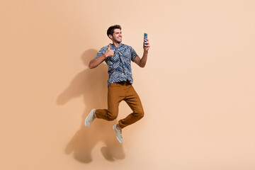 Full length body photo of jumping guy blogger shows like feedback at his video recording on...