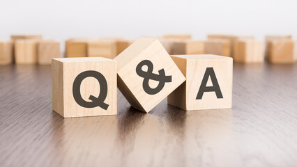 Q and A text on wooden blocks. wooden background. foreground