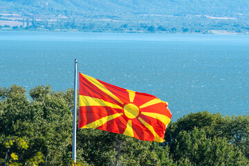 Red and yellow colors. Macedonian flag,national symbol, waving. Beautiful landscape. Amazing nature. Dojran lake Macedonia 2023