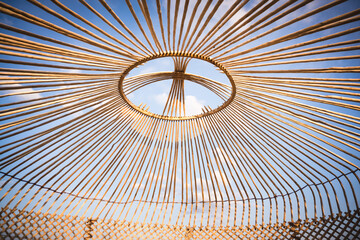 The frame of the yurt is on top of the dome, the wooden poles of the yurt are intertwined and connected at the top of the shanyrak