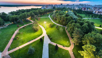 top view aerial photo from flying drone of a city park with walking path and green zone trees in...