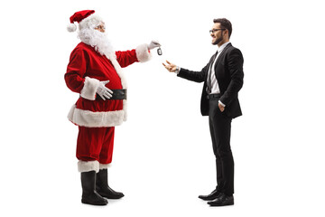 Full length profile shot of santa claus giving car keys to a businessman