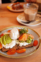 Cottage cheese, avocado, and smoked salmon cracker with poached egg on top