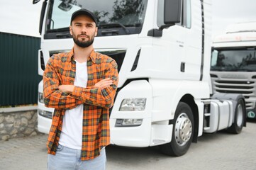 Portrait of young bearded trucker standing by his truck vehicle. Transportation service. Truck driver job