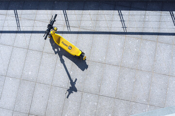 Top view of the Yellow Yandex electric scooter standing on the asphalt on the embankment,a beautiful urban photo with a place for text. Saint Petersburg, Russia - 5 Aug 2023