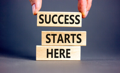 Success starts here symbol. Concept word Success starts here on beautiful wooden block. Businessman...