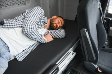 Truck driver enjoying comfortable cabin bed inside his truck