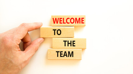 Welcome to the team symbol. Concept words Welcome to the team on wooden block. Beautiful white table white background. Businessman hand. Business, motivational and welcome to the team concept.