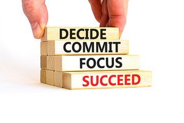 Decide commit focus succeed symbol. Concept word Decide Commit Focus Succeed on wooden block. Beautiful white background. Businessman hand. Business decide commit focus succeed concept. Copy space.