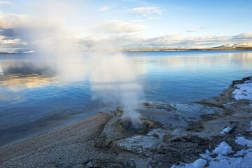 Lake Shore Geysers next to Yellowstone Lake winter landscape at sunset in Yellowstone National Park Wyoming.