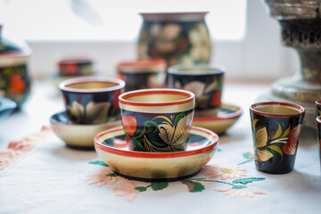 Traditional Russian wooden painted tableware. Hand painted mugs and cups made of wood.