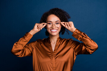 Photo of positive successful businesswoman ry new spectacles for good vision isolated over blue...