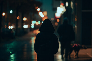 Anonymous Individual in Cityscape at Night Looking Towards Illuminated Downtown