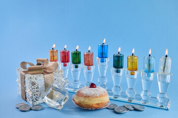 Jewish holiday Hanukkah with menorah, traditional Candelabra, donut and dreidel, spinning top.