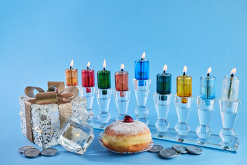Jewish holiday Hanukkah with menorah, traditional Candelabra, donut and dreidel, spinning top.