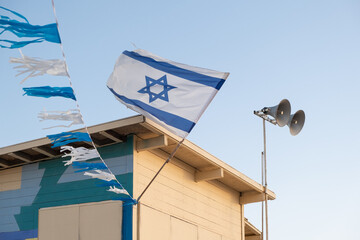 Israeli flag with the Star of David symbol proudly adorns a lifeguard booth on the  beach of Israel.