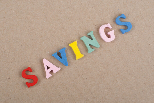 SAVINGS word on wooden background composed from colorful abc alphabet block wooden letters, copy space for ad text. Learning english concept.