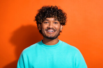 Portrait of cheerful funky friendly young man beaming smile good mood isolated on orange color background