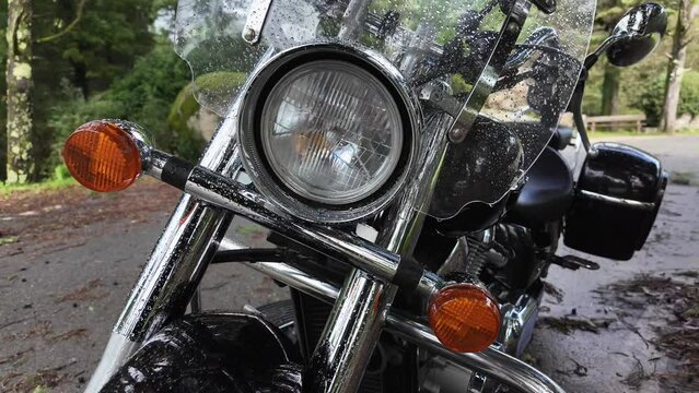 front part, headlight with raindrops of a classic motorcycle, close-up, 4k slow motion