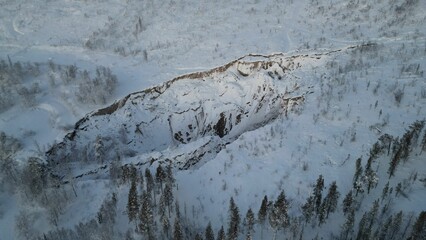 Obraz premium Aerial view of white snow-covered rural field and valleys