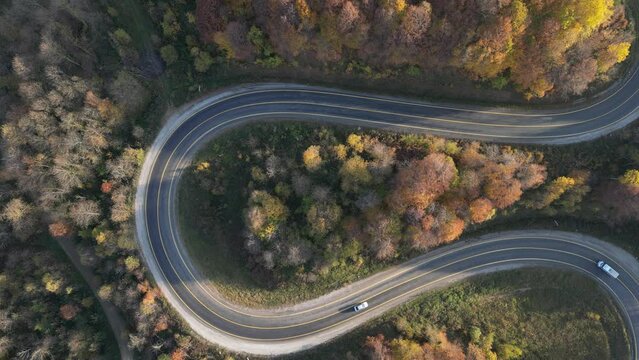 Curvy mountain roads in autumn. Vehicles in motion on winding mountain roads. 