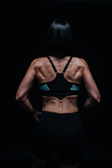 Naklejka premium woman with arms outstretched. female athlete standing with her back in a top and shorts. 
