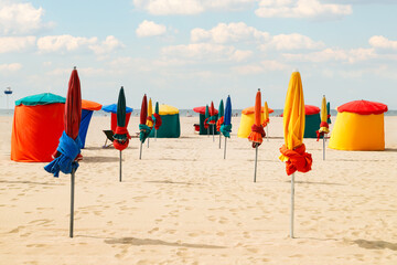 Deauville Beach, famous resort in Normandy, Northern France. Colourful traditional beach huts and parasols, landmark of the resort.