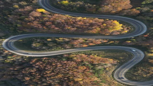 Curvy mountain roads in autumn. Vehicles in motion on winding mountain roads. 