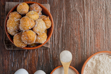 Fototapeta na wymiar Fried fritters covered in sugar. Typical of Argentine homemade pastries.