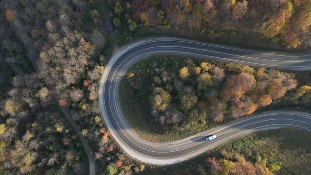 Curvy mountain roads in autumn. Vehicles in motion on winding mountain roads. 