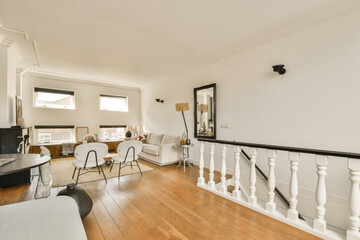 a living room with white walls and hardwood flooring, including a staircase leading up to the upper landing area