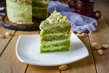 A piece of pistachio cake for dessert on a plate. Close-up