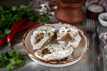 Slices of pink salmon in cream sauce on a plate. Close-up