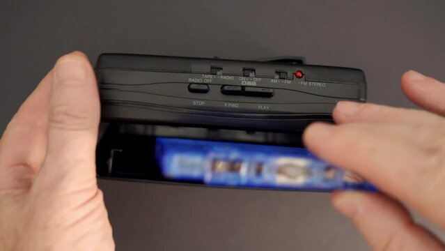Inserting a cassette tape into a Walkman.
