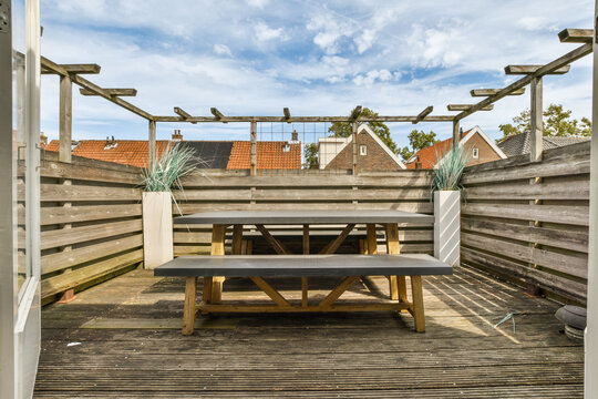 a wooden deck with a picnic table and benches in the fore - image was taken from an instap