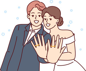 Marriage ceremony of man and woman, with wide smile showing wedding rings on fingers