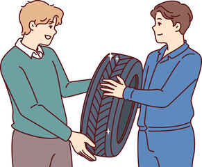Fototapeta premium Man buys new tires for car wheel and consults mechanic, who help make right choice