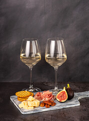 Food photography of white wine; cheese; parmesan; fig;  prosciutto, pecan, cracker,  wineglass; bottle; chardonnay, sauvignon, winery