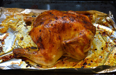 whole baked chicken with a crispy golden crust. meat cooked in the oven. cooking in the home kitchen. delicious lunch or dinner. dish for the festive table