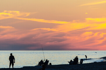 Fototapeta premium people enjoying the beach at sunset