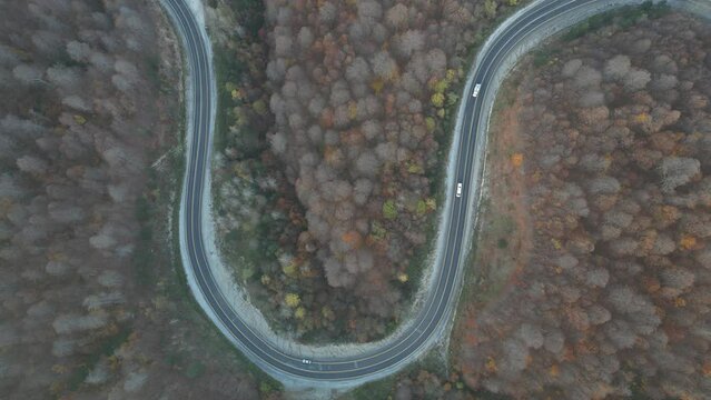 Curvy mountain roads in autumn. Vehicles in motion on winding mountain roads. 