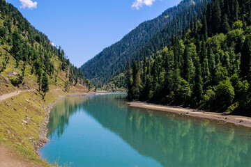 Fototapeta na wymiar Picture of Mountain, Trees, River and Stream of adjoining areas of Kashmir. In this picture you can see the hill view along with stream and trees with beautiful scene of greenery on mountains